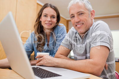 Couple using a laptop while having tea
