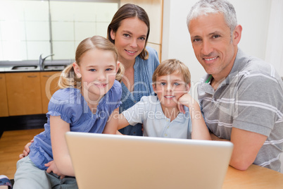 Charming family using a laptop