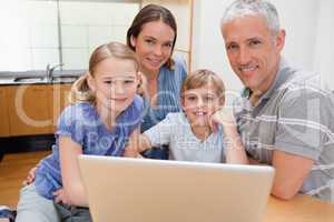 Charming family using a laptop
