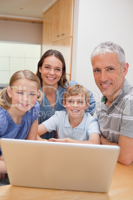 Portrait of a charming family using a laptop