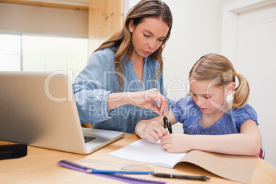 Woman helping her daughter doing her homework