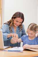 Portrait of a mother helping her daughter doing her homework