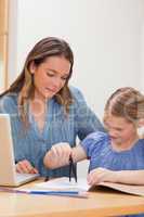 Portrait of a woman helping her daughter doing her homework