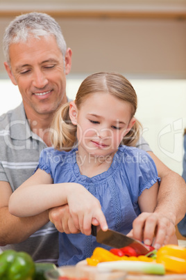 Portrait of a father showing his daughter how to cook
