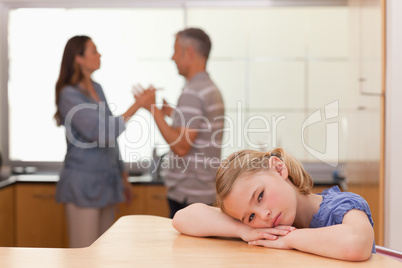 Sad girl hearing her parents arguing