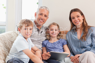 Smiling family using a tablet computer