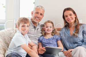 Smiling family using a tablet computer