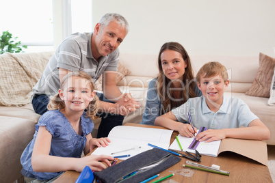 Happy parents helping her children to do their homework