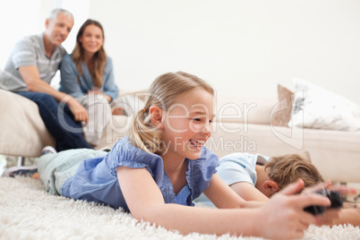 Children playing video games with their parents on the backgroun