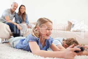 Children playing video games with their parents on the backgroun