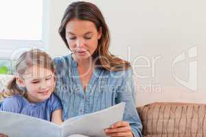 Mother reading a book to her daughter