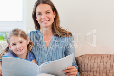 Happy mother reading a book to her daughter