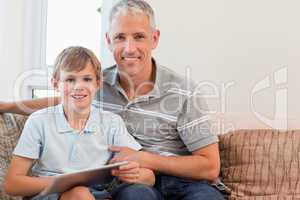 Smiling father and his son using a tablet computer