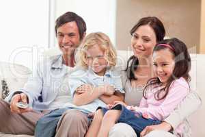 Smiling family watching television together