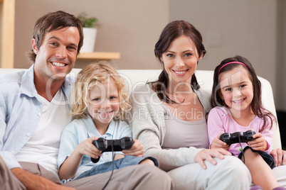 Smiling family playing video games together