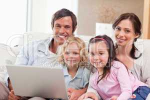 Delighted family using a laptop