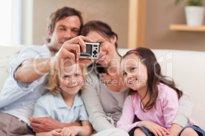 Happy father taking a picture of his family