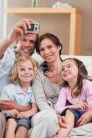 Portrait of a happy father taking a picture of his family