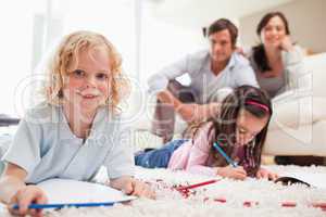 Children drawing while their parents are in the background