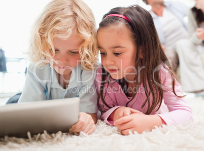 Children using a tablet computer while their parents are in the