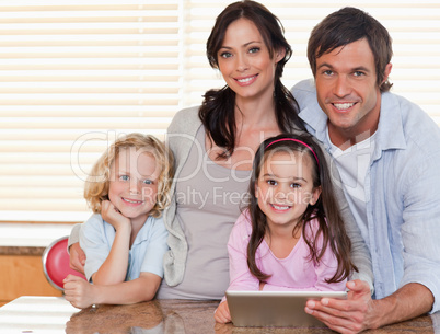 Smiling family using a tablet computer together