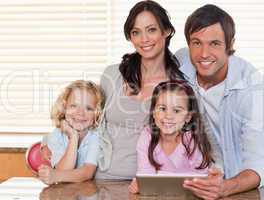 Smiling family using a tablet computer together