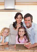 Portrait of a smiling family using a tablet computer together
