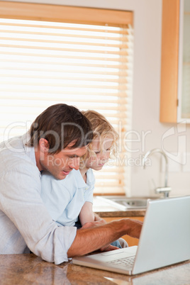 Portrait of a boy and his father using a laptop together
