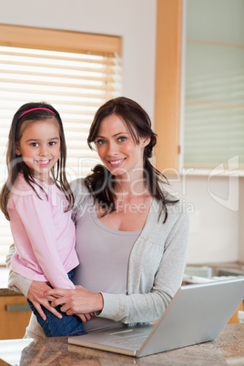 Portrait of a girl and her mother using a notebook