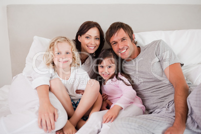 Happy family posing on a bed