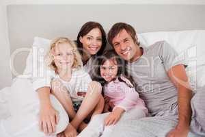 Happy family posing on a bed