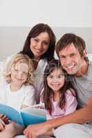 Portrait of a happy family reading a book