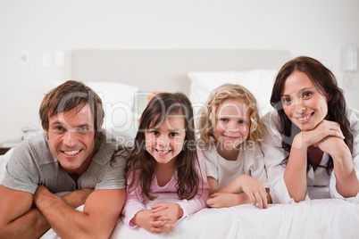 Happy family lying in a bed