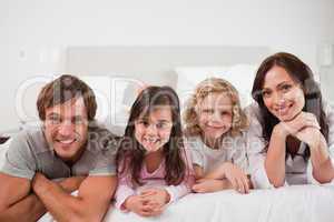 Happy family lying in a bed