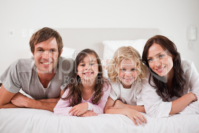 Cheerful family lying in a bed
