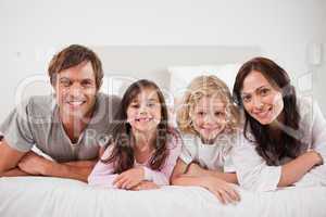 Cheerful family lying in a bed