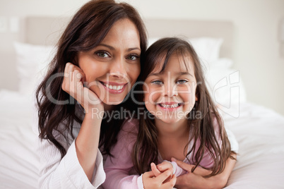 Mother and her daughter lying on a bed
