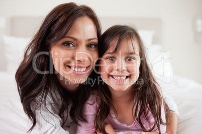 Girl and her mother lying on a bed