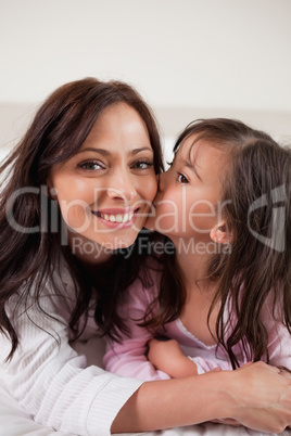 Portrait of a girl kissing her mother