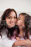 Portrait of a girl kissing her mother