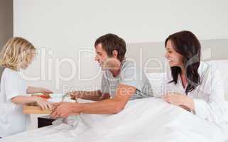 Lovely boy bringing breakfast to his parents