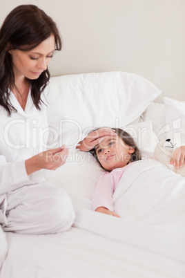 Portrait of a mother checking on her daughter's temperature