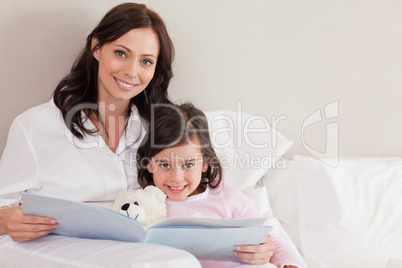 Happy mother reading a story to her daughter