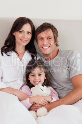 Portrait of parents posing with their daughter