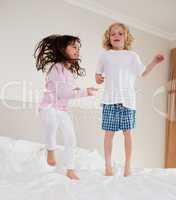 Portrait of siblings jumping