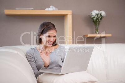 Cheerful woman with her notebook on the sofa