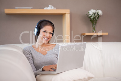 Woman with notebook and headphones on the sofa