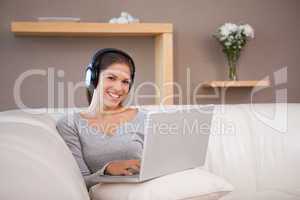Woman with notebook and headphones on the sofa