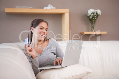 Smiling woman shopping online on the sofa