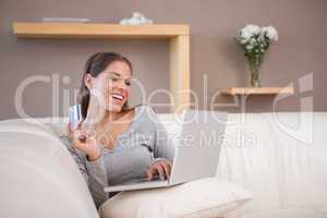 Smiling woman shopping online on the sofa
